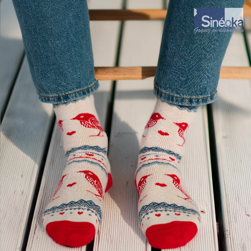 Chaussettes style scandinave Fugl, les 2 pieds sur des lames de terrasse, au soleil.