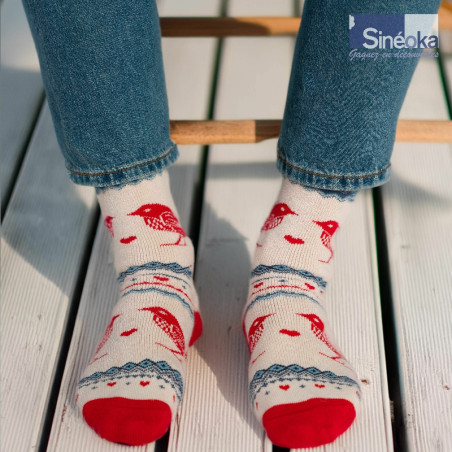 Chaussettes style scandinave Fugl, les 2 pieds sur des lames de terrasse, au soleil.