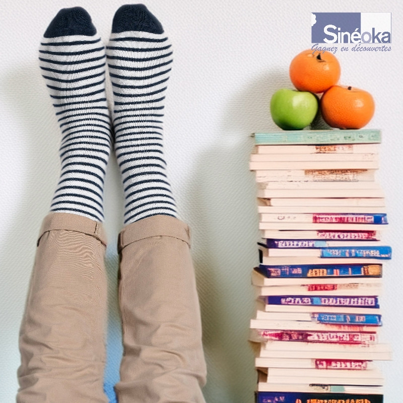 Sømand, des chaussettes chaudes au style marin scandinave une pile de livres et des fruits.