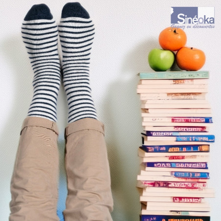 Sømand, des chaussettes chaudes au style marin scandinave une pile de livres et des fruits.