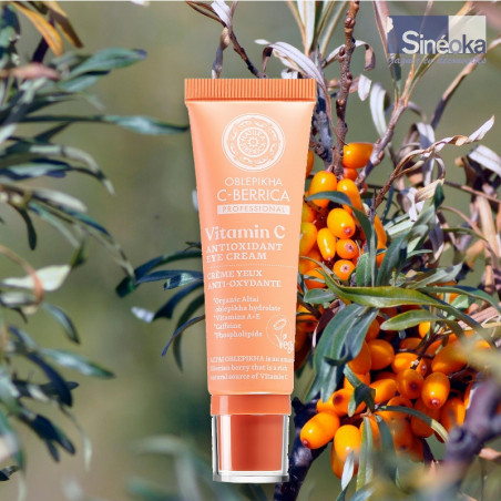 Tube de crème Contour des Yeux Anti-Âge à l’Argousier de Natura Siberica sur fond de baies d'argousier sauvages.